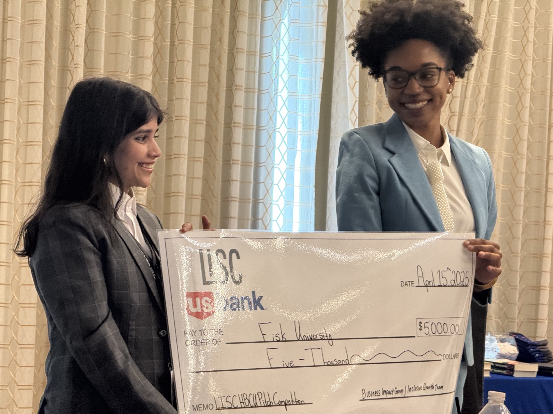 Sam and a teammate holding their LISC and U.S. Bank award check